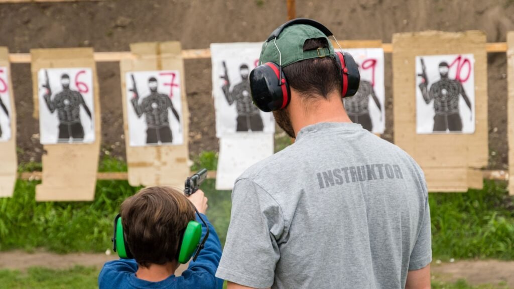 firearm instructor with a kid in a shooting range