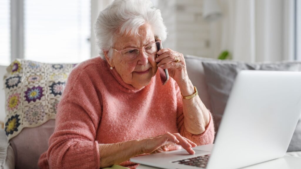 a senior woman on a call in front of her laptop
