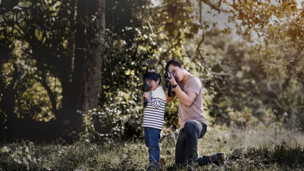 joyful happy Father and son with playing gun in the forest
