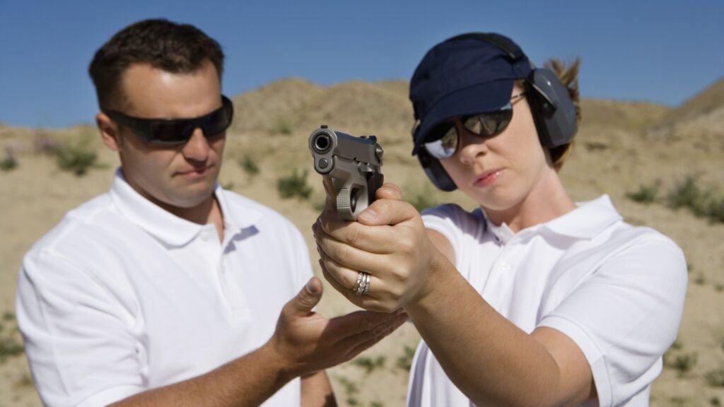 a woman using a handgun at a firing range
