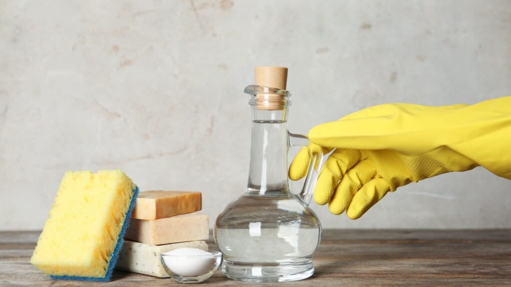 a bottle of vinegar with cleaning supplies
