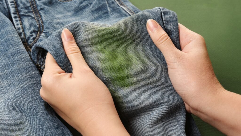 woman holding jeans with grass stain
