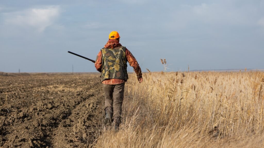 a man with a hunting rifle in a hunting field
