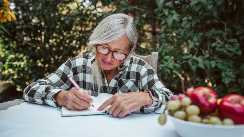 senior woman writing on journal
