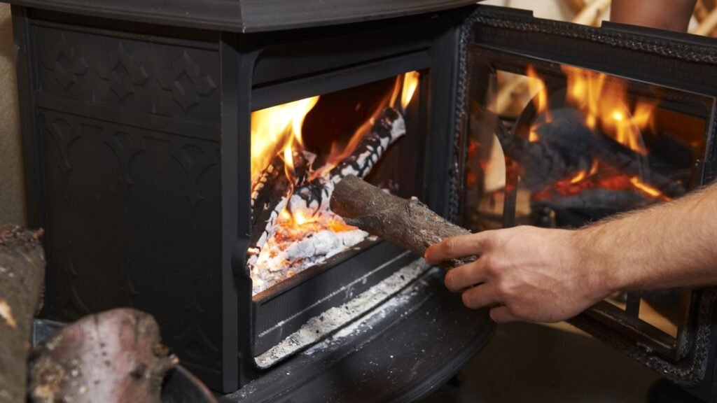 putting log in a wood-burning stove
