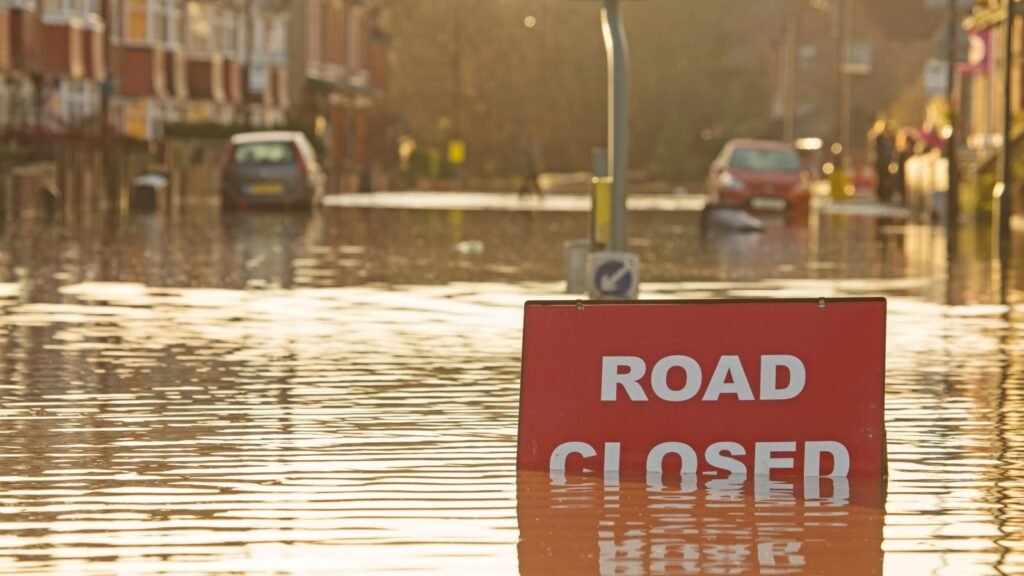 road closed sign partially covered in flood
