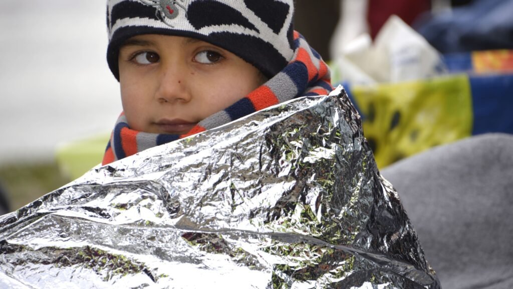 a kid covered with emergency blanket
