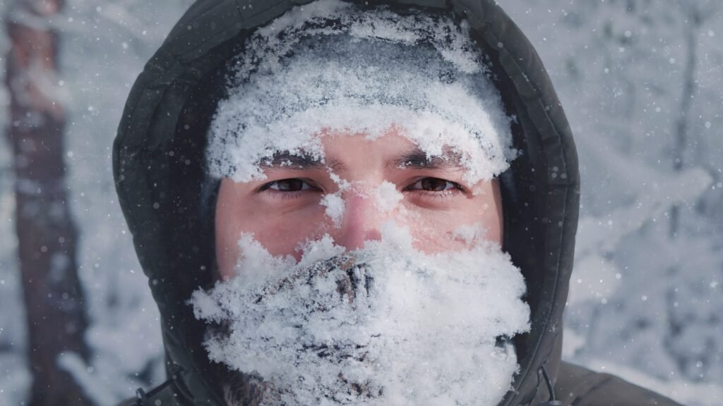 Man covered with snow in the face winter storm