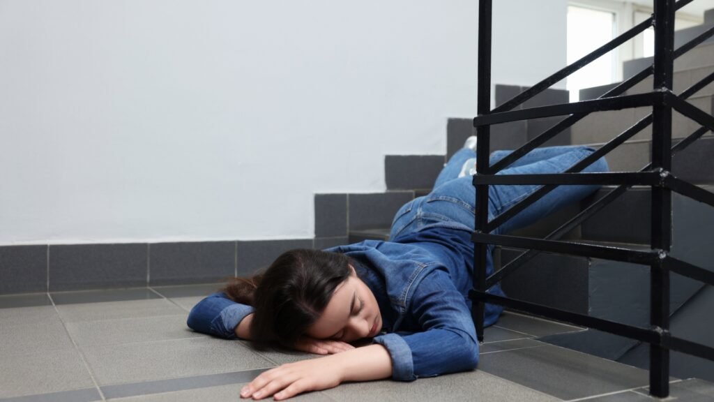 woman lying on the floor after falling down the stairs