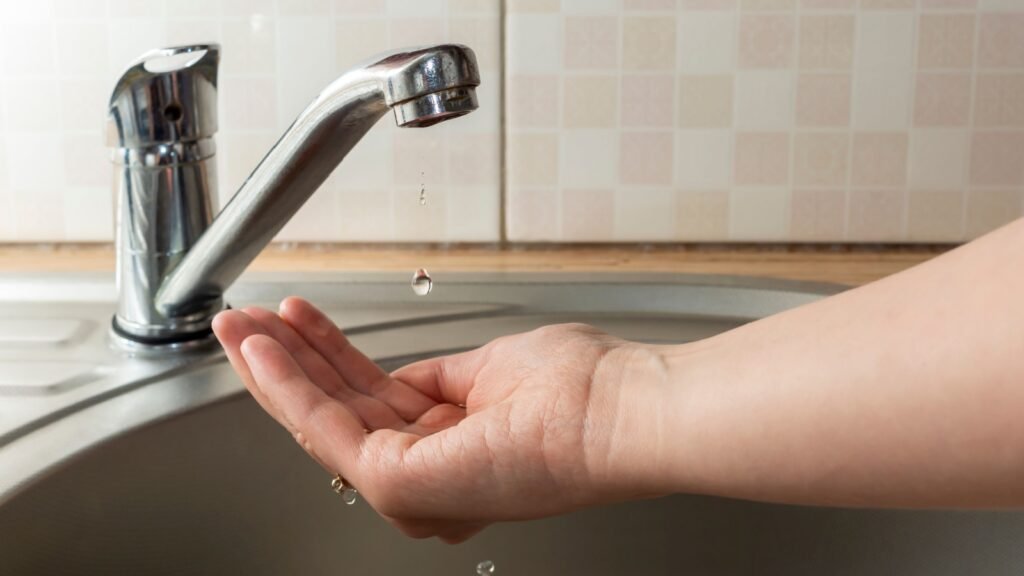  water drips from faucet in human palm