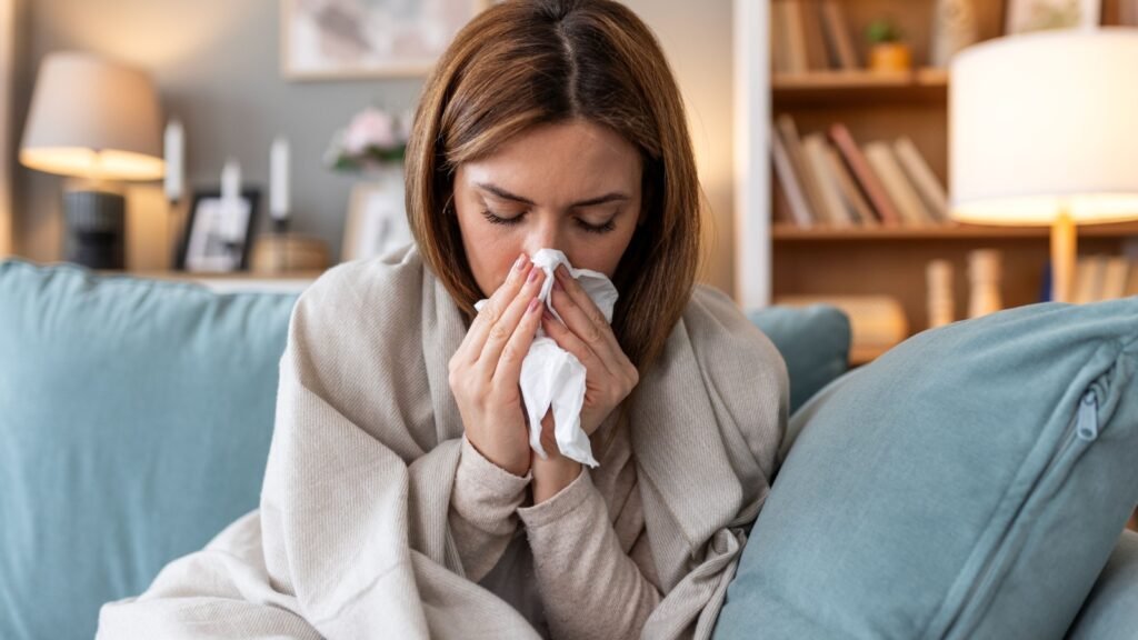 woman being sick having flu lying on sofa