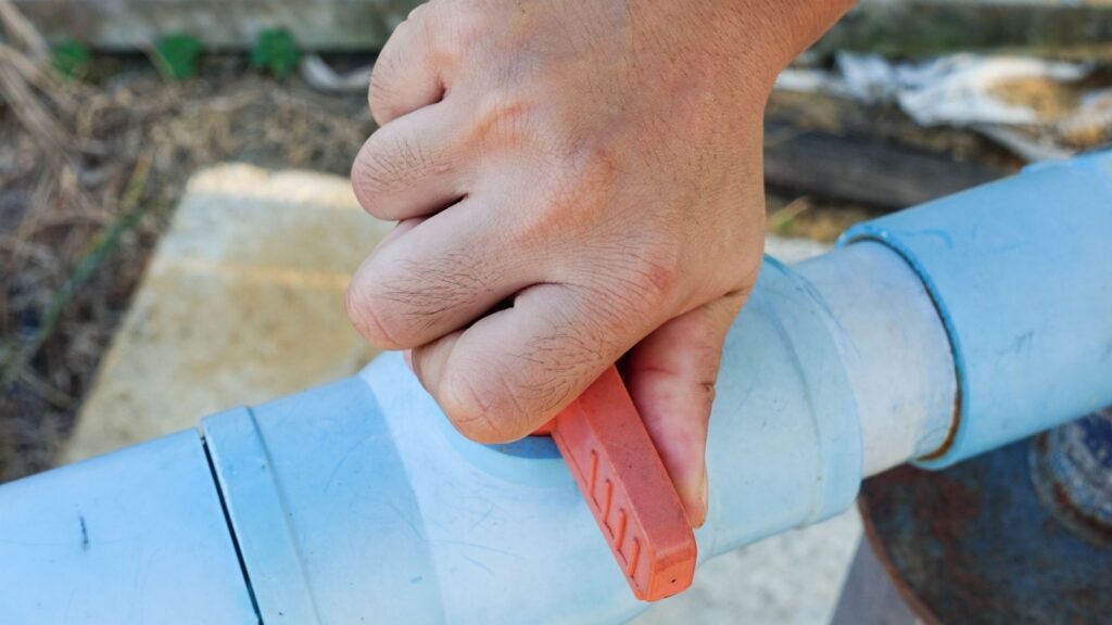 a hand carefully turning a safety shut-off valve