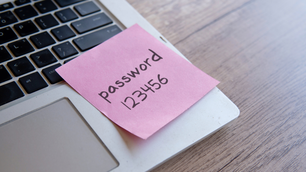 Sticky note with the word _password 123456_ on a laptop keyboard