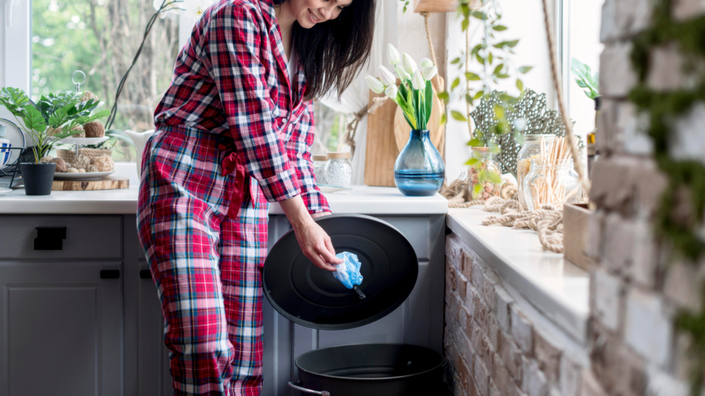 Woman throwing trash in bin 