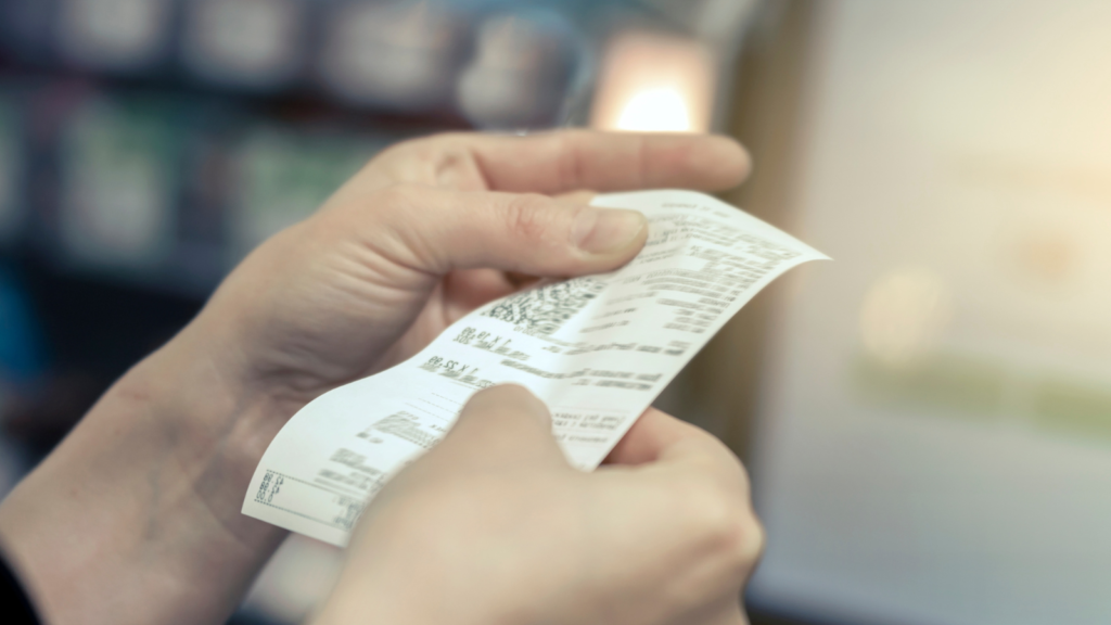 the girl looks at the receipt in the store